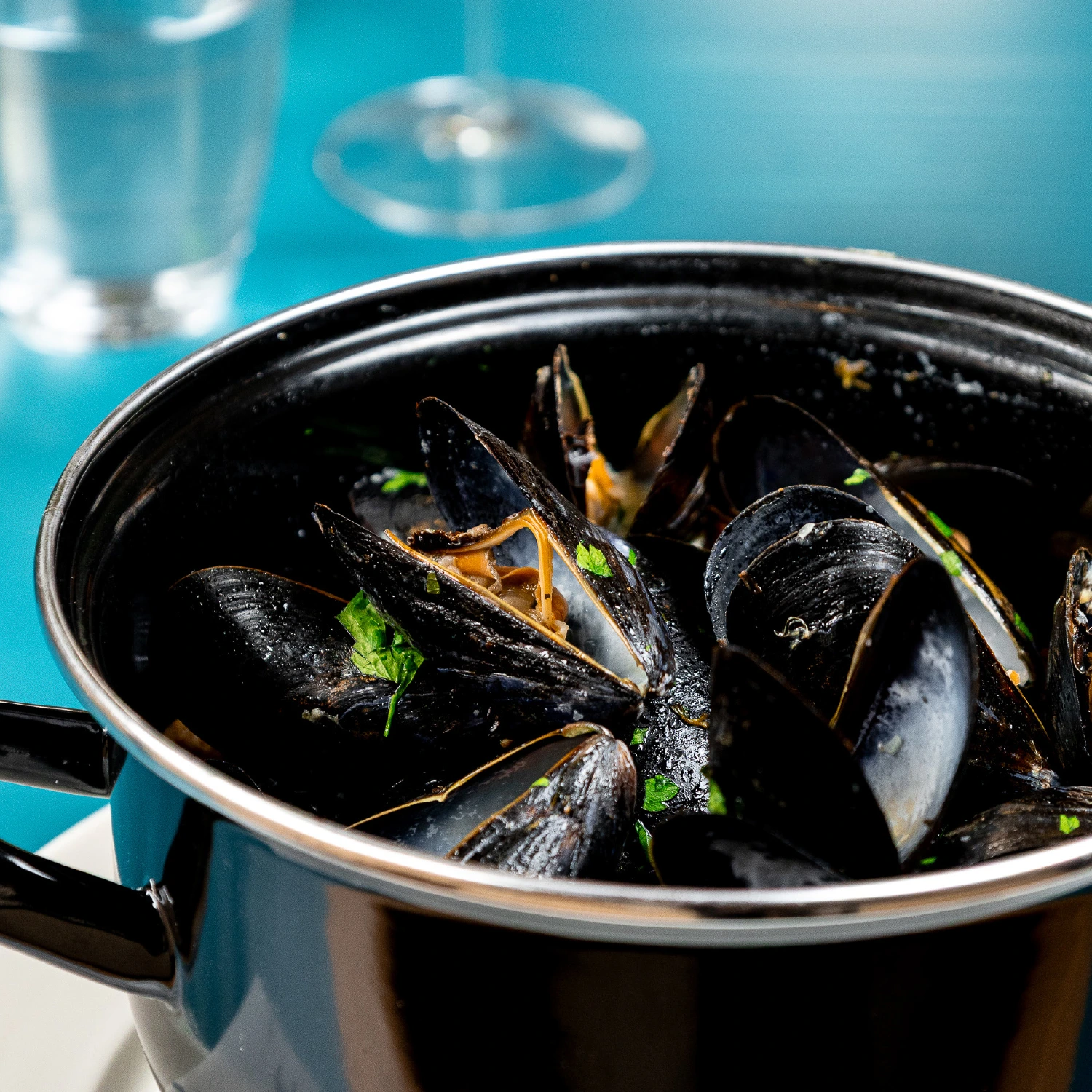 a pot of mussels with parsley