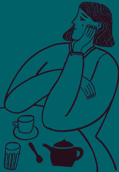 A person seated at a table rests their chin on one hand, looking away, with a teapot, cup on saucer, glass, and spoon placed on the tabletop.